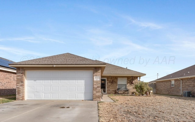 single story home with a garage, cooling unit, concrete driveway, and roof with shingles