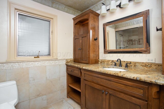 2615 S Hayden St, Amarillo, TX 79109 - bathroom featuring tile walls, vanity, and a wainscoted wall
