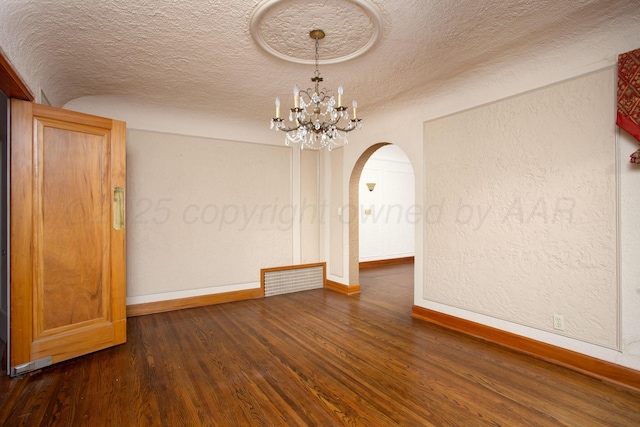 2615 S Hayden St, Amarillo, TX 79109 - empty room featuring arched walkways, a textured ceiling, wood finished floors, and a chandelier