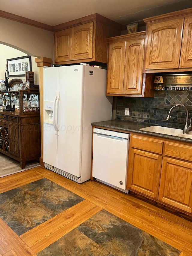 14680 County Road 6, Booker, TX 79005 - kitchen featuring white appliances, a sink, dark countertops, light wood-style floors, and tasteful backsplash