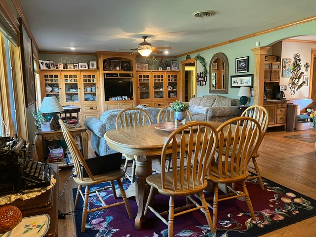 14680 County Road 6, Booker, TX 79005 - dining room with arched walkways, ornamental molding, a ceiling fan, and wood finished floors