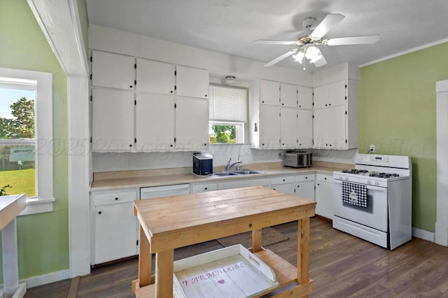 110 N Houston St, Shamrock, TX 79079 - kitchen with white range with gas stovetop, white cabinetry, light countertops, dark wood finished floors, and ceiling fan