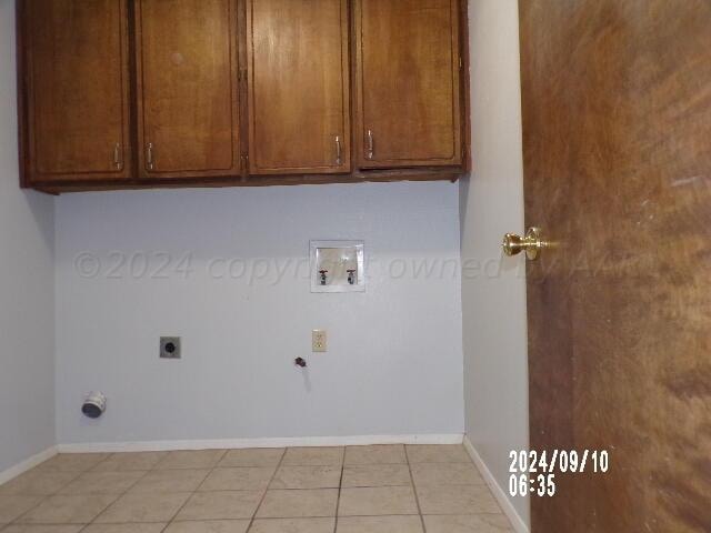 laundry area with hookup for a washing machine, cabinets, light tile patterned floors, and hookup for an electric dryer