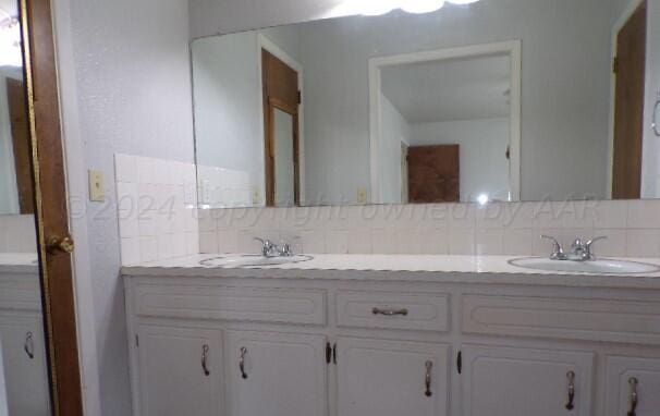 bathroom featuring tasteful backsplash and vanity