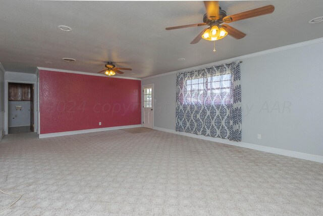 carpeted spare room featuring ornamental molding, a textured ceiling, and ceiling fan