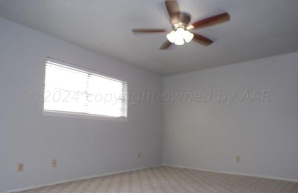 spare room with light carpet and ceiling fan