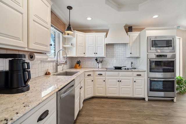 7809 Tarter Ave, Amarillo, TX 79121 - kitchen featuring appliances with stainless steel finishes, premium range hood, crown molding, white cabinets, and light wood-style flooring