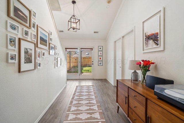7809 Tarter Ave, Amarillo, TX 79121 - hallway with ornamental molding, wood finished floors, a chandelier, and vaulted ceiling