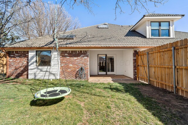 7809 Tarter Ave, Amarillo, TX 79121 - back of property with brick siding, a fenced backyard, a patio area, and a tiled roof