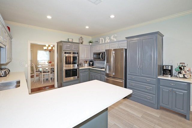 kitchen featuring sink, decorative backsplash, gray cabinets, ornamental molding, and stainless steel appliances