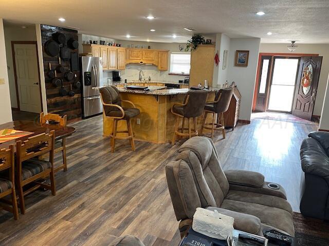 living room with wood-type flooring, sink, and a textured ceiling