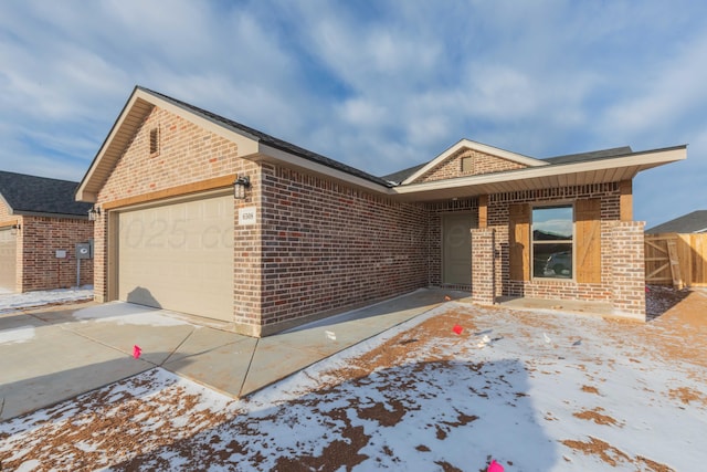 single story home featuring a garage, concrete driveway, and brick siding