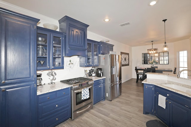 6508 Bayberry Ln, Amarillo, TX 79124 - kitchen featuring stainless steel appliances, blue cabinets, a sink, decorative light fixtures, and light wood-style floors