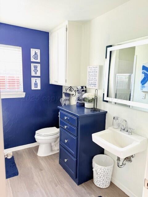 6508 Bayberry Ln, Amarillo, TX 79124 - bathroom featuring wood finished floors, toilet, a sink, and baseboards