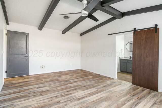 6206 Yale St, Amarillo, TX 79109 - unfurnished room with a barn door, a ceiling fan, and light wood-style flooring