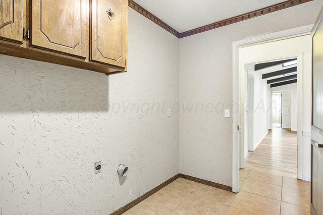 6206 Yale St, Amarillo, TX 79109 - laundry room with cabinet space, light tile patterned flooring, hookup for an electric dryer, and a textured ceiling