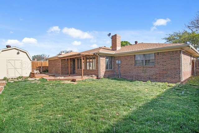 6206 Yale St, Amarillo, TX 79109 - rear view of property featuring a storage unit, a chimney, brick siding, and a deck