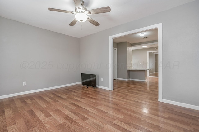 unfurnished room featuring light wood-type flooring, ceiling fan, and baseboards