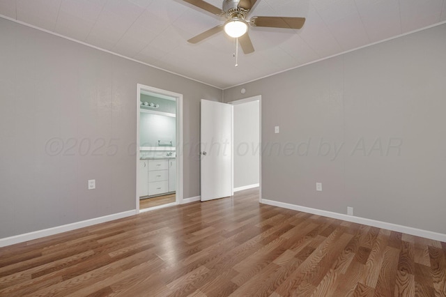 unfurnished bedroom featuring baseboards, ornamental molding, and wood finished floors