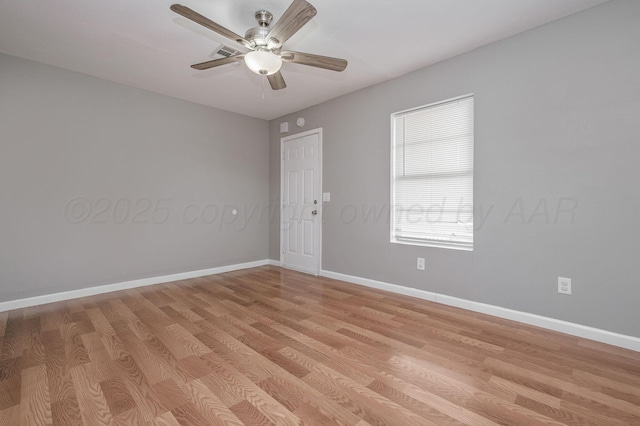 unfurnished room featuring ceiling fan, light wood-type flooring, visible vents, and baseboards