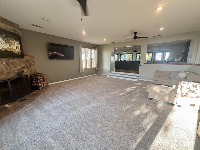 unfurnished living room with a baseboard radiator, a wealth of natural light, carpet floors, and ceiling fan