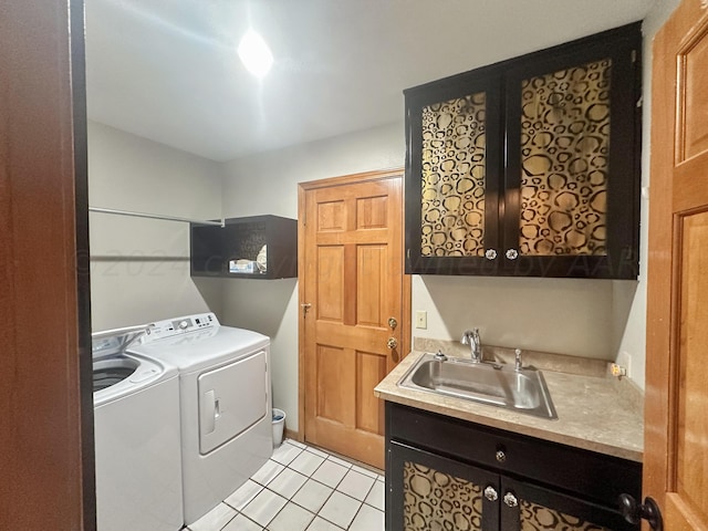 laundry room with cabinets, light tile patterned flooring, sink, and washer and dryer