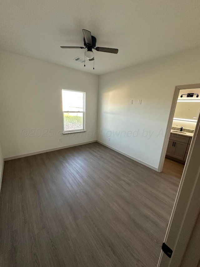 218 Michael Ave, Dumas, TX 79029 - unfurnished room featuring wood finished floors, a ceiling fan, baseboards, and a sink