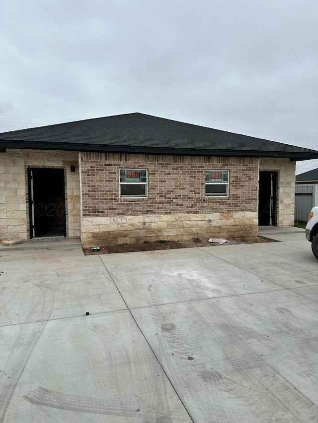 218 Michael Ave, Dumas, TX 79029 - view of front of home featuring roof with shingles and stone siding