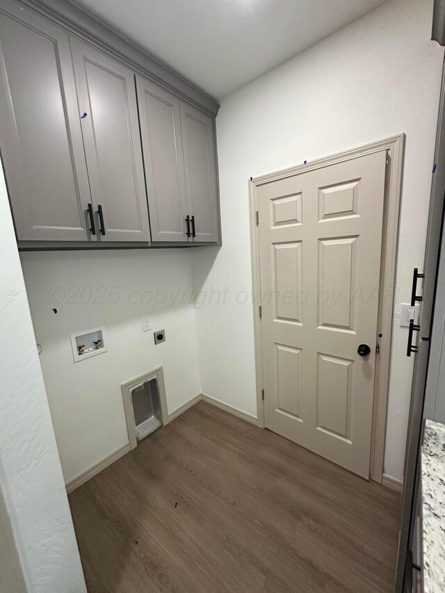 218 Michael Ave, Dumas, TX 79029 - laundry room with cabinet space, hookup for an electric dryer, dark wood-type flooring, baseboards, and hookup for a washing machine