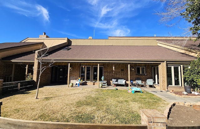 back of house featuring a lawn and a patio