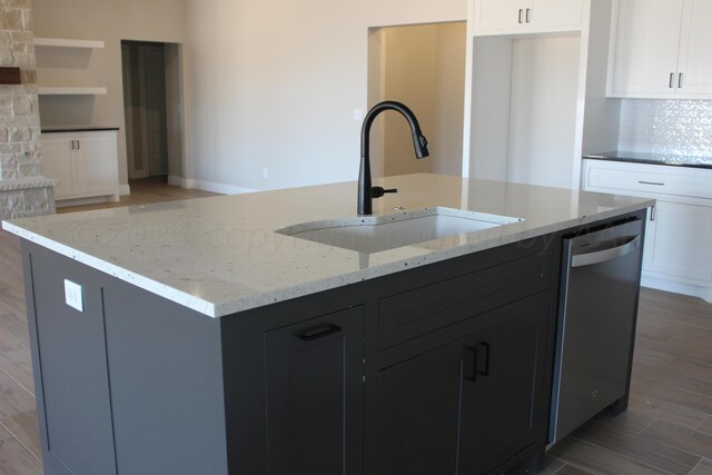 8104 Miami Ave, Amarillo, TX 79118 - kitchen with stainless steel dishwasher, a sink, an island with sink, white cabinets, and light stone countertops