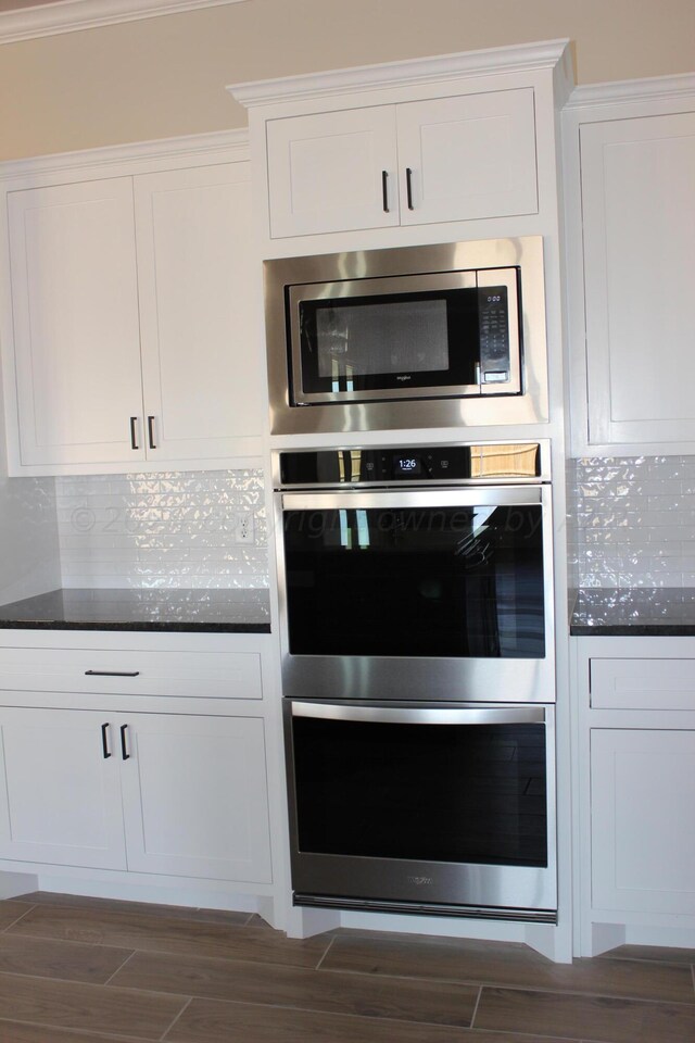 8104 Miami Ave, Amarillo, TX 79118 - kitchen with stainless steel appliances, white cabinetry, dark wood-style flooring, and tasteful backsplash