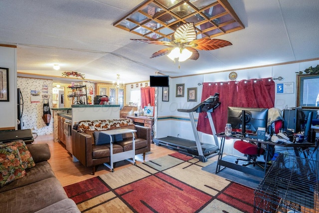 interior space featuring vaulted ceiling, ornamental molding, ceiling fan with notable chandelier, and light wood-style flooring