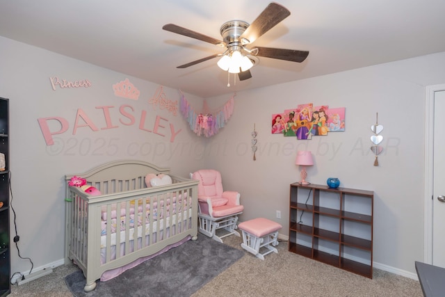 bedroom featuring a nursery area, carpet, baseboards, and ceiling fan