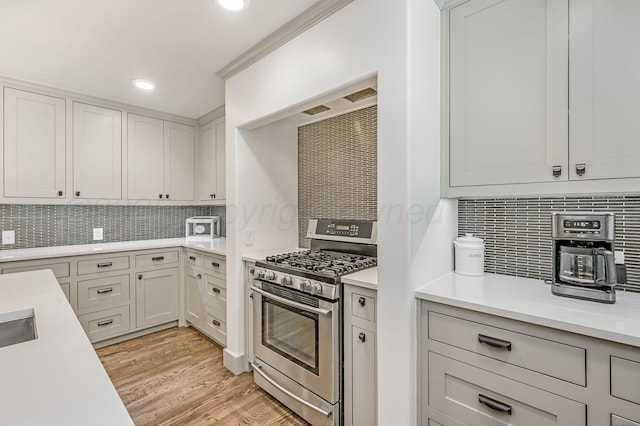 4407 SW 3rd Ave, Amarillo, TX 79106 - kitchen featuring light countertops, backsplash, stainless steel gas range, light wood finished floors, and recessed lighting