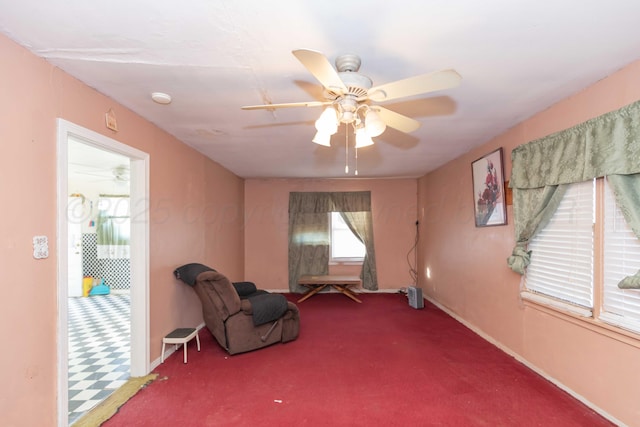 living area with carpet flooring, ceiling fan, and baseboards