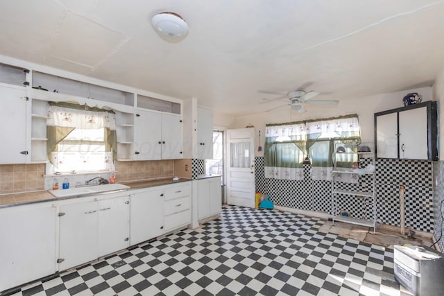 kitchen featuring white cabinets, light floors, open shelves, and a sink