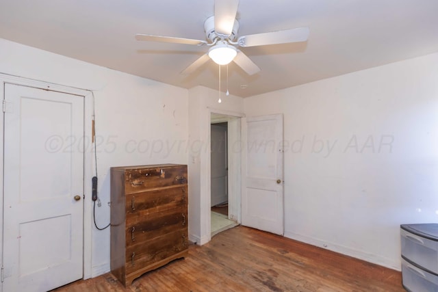 bedroom featuring a ceiling fan, baseboards, and wood finished floors