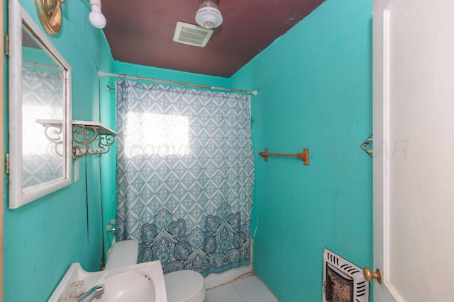 full bath featuring visible vents, toilet, heating unit, tile patterned flooring, and tile walls