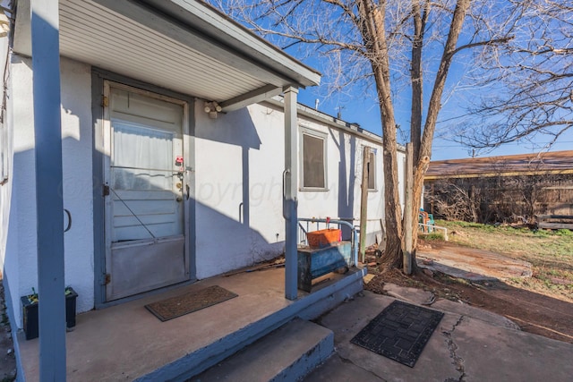 entrance to property featuring stucco siding