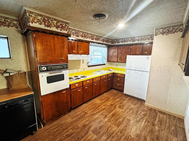 kitchen featuring white appliances, wood-type flooring, and a textured ceiling