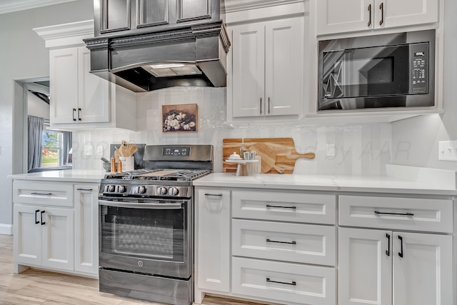 1600 NE 6th St, Dumas, TX 79029 - kitchen with decorative backsplash, custom exhaust hood, white cabinetry, built in microwave, and gas stove