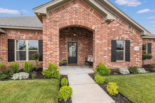 1600 NE 6th St, Dumas, TX 79029 - entrance to property with a shingled roof, a yard, and brick siding