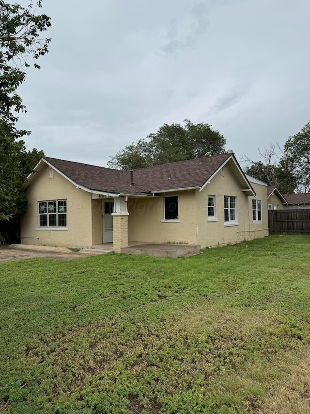 back of property featuring a patio and a lawn