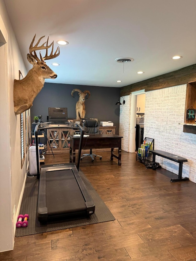 1711 N Holly Ln, Pampa, TX 79065 - exercise room with wood finished floors, recessed lighting, and brick wall