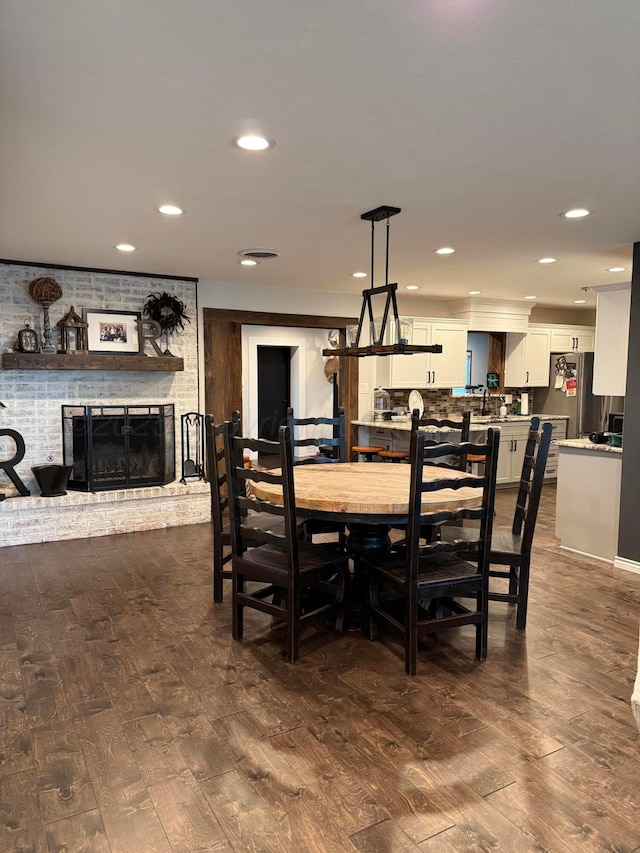 1711 N Holly Ln, Pampa, TX 79065 - dining room with dark wood finished floors, a brick fireplace, and recessed lighting