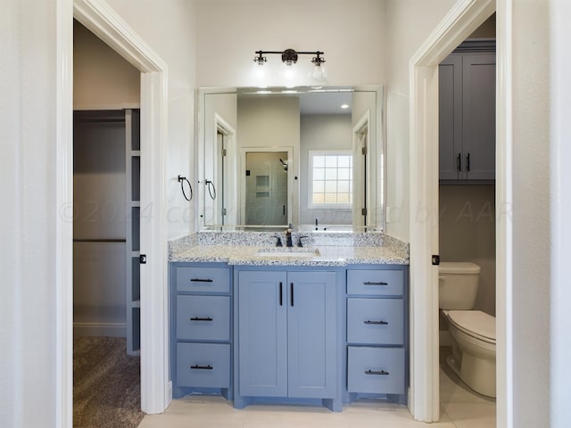 bathroom featuring an enclosed shower, vanity, tile patterned floors, and toilet