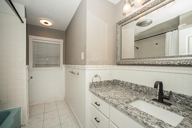 3122 Nebraska St, Amarillo, TX 79106 - full bath featuring marble finish floors, vanity, wainscoting, and shower / tub combo with curtain