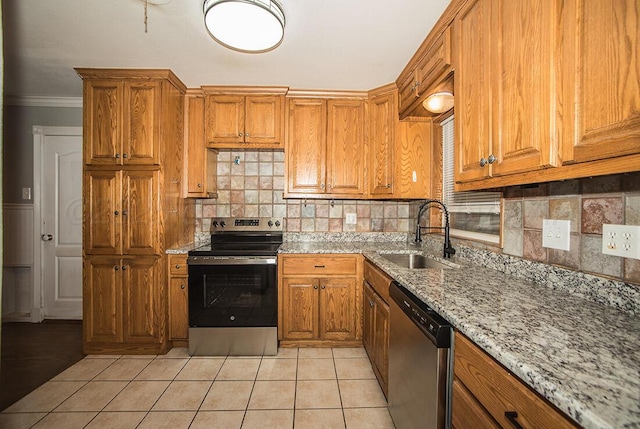 3122 Nebraska St, Amarillo, TX 79106 - kitchen featuring appliances with stainless steel finishes, light stone countertops, tasteful backsplash, brown cabinets, and crown molding