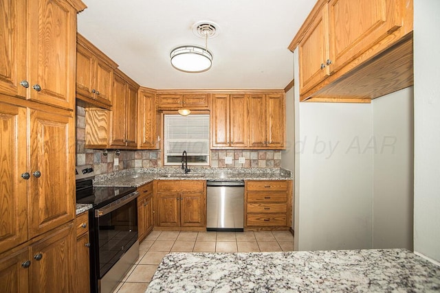 3122 Nebraska St, Amarillo, TX 79106 - kitchen with appliances with stainless steel finishes, decorative backsplash, light stone counters, and light tile patterned floors